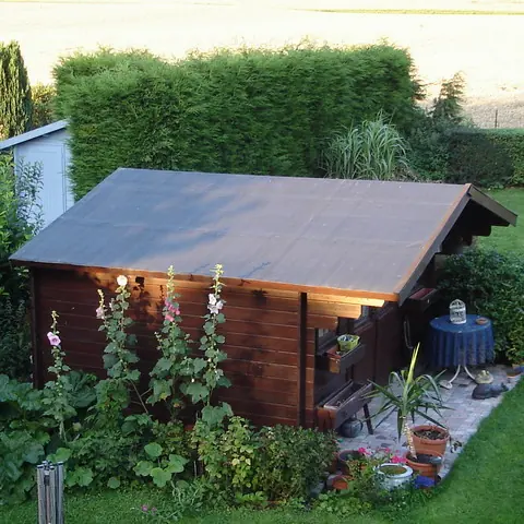 Abri bois toit deux pans couvert d'EPDM, jardin fleuri