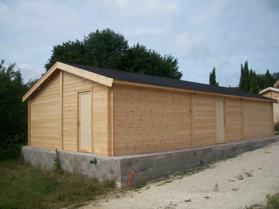 Long garage en madriers sur soubassement, pignon