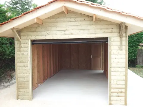 Garage ossature bardé bois, avant-toit en tuiles, porte ouverte