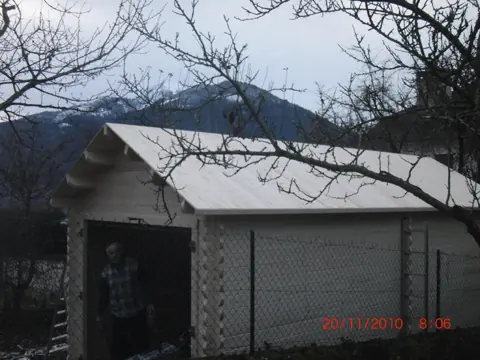 Garage en madriers voligé, montagnes enneigées
