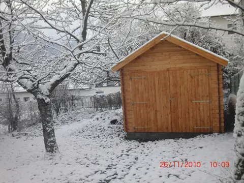 Pignon de garage en madriers lasuré sous la neige