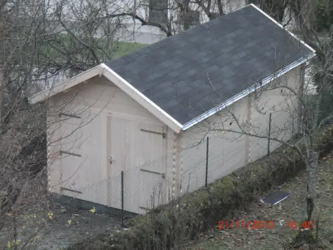 Garage en madriers brut couvert de bardeaux