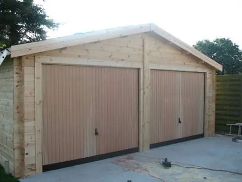 Garage double en madriers, deux portes basculantes
