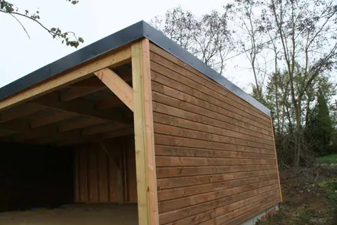 Garage toit plat lasuré brun avec partie ouverte