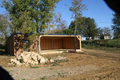 Garage toit plat avec partie ouverte, pierres