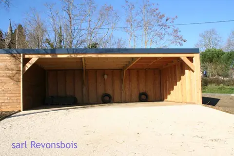 Carport accolé à un garage toit plat, sol sablé