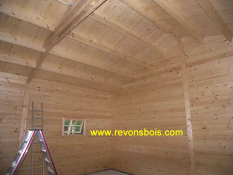 Intérieur de garage en madriers, fenêtre et échelle
