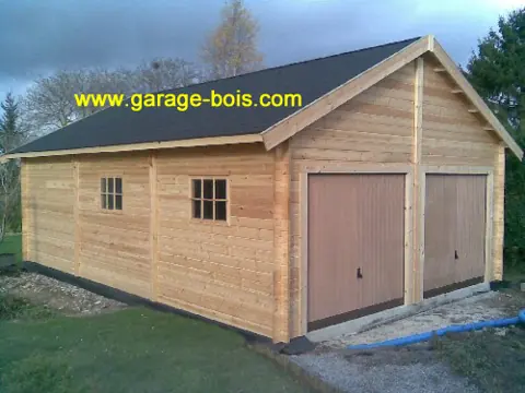 Garage double en madriers, toit bardeaux, ciel bleu