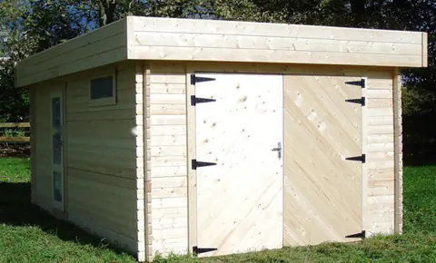 Garage toit plat en madriers, porte bois double