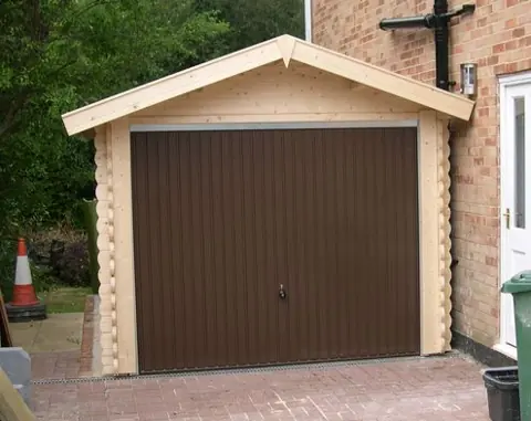 Garage en madriers, porte basculante brune