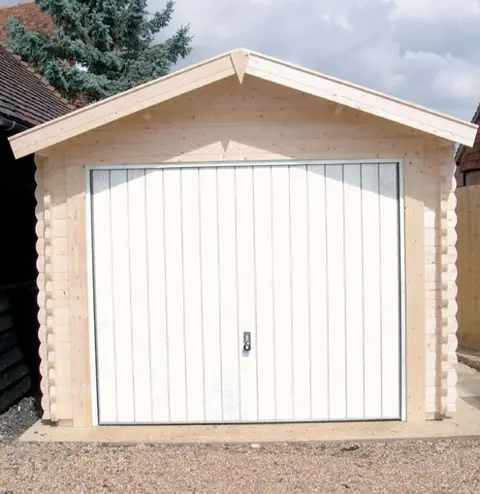 Garage en madriers, porte basculante blanche