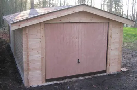 Garage en madriers brut, porte pleine