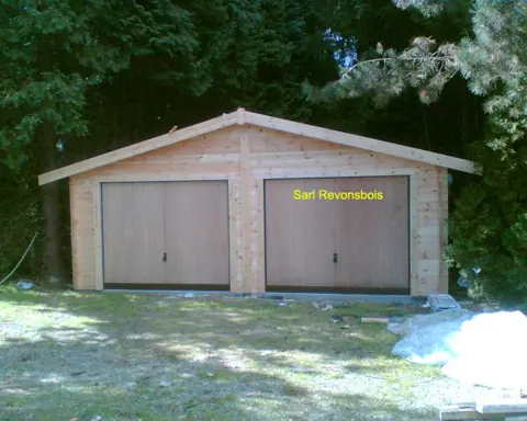Garage double en madriers dans un sous-bois