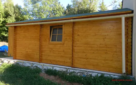 Façade de garage en madriers lasuré avec fenêtre