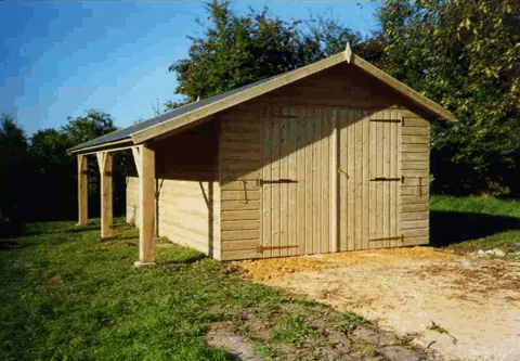 Garage ossature bardé avec auvent latéral