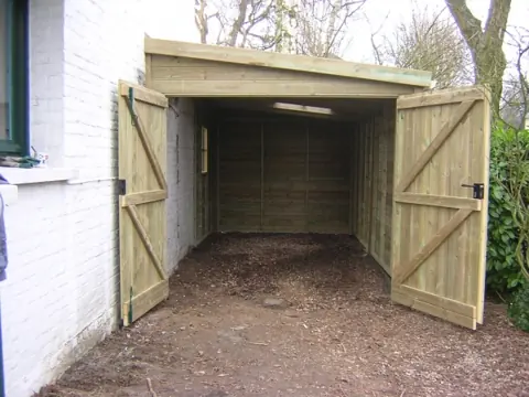 Garage ossature ouvert accolé à une maison