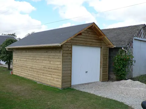 Garage ossature bardé, porte sectionnelle blanche