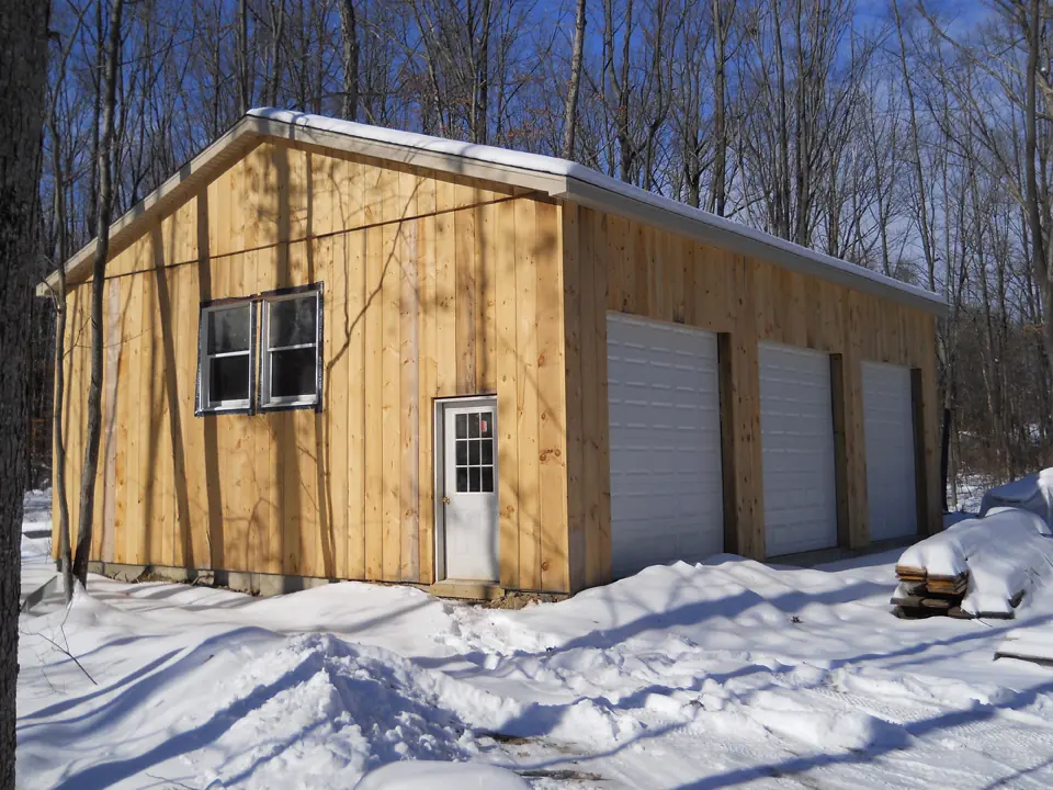 Garage ossature bardé bois sous la neige