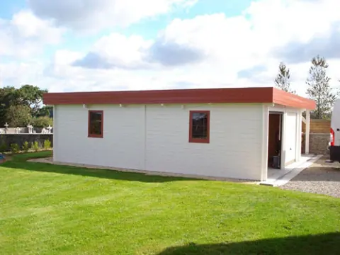 Garage toit plat peint blanc, pelouse