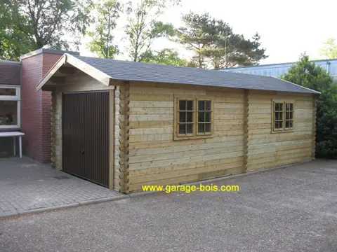 Long garage en madriers, porte brune et fenêtres