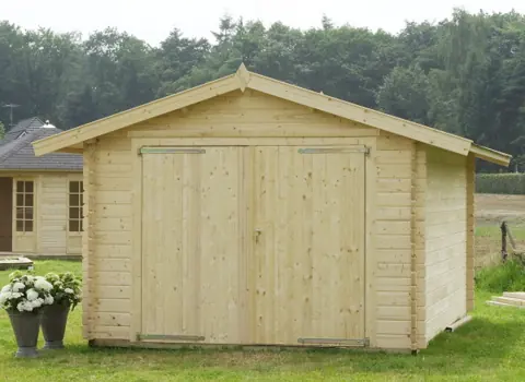 Garage en madriers brut, porte double, massif fleuri
